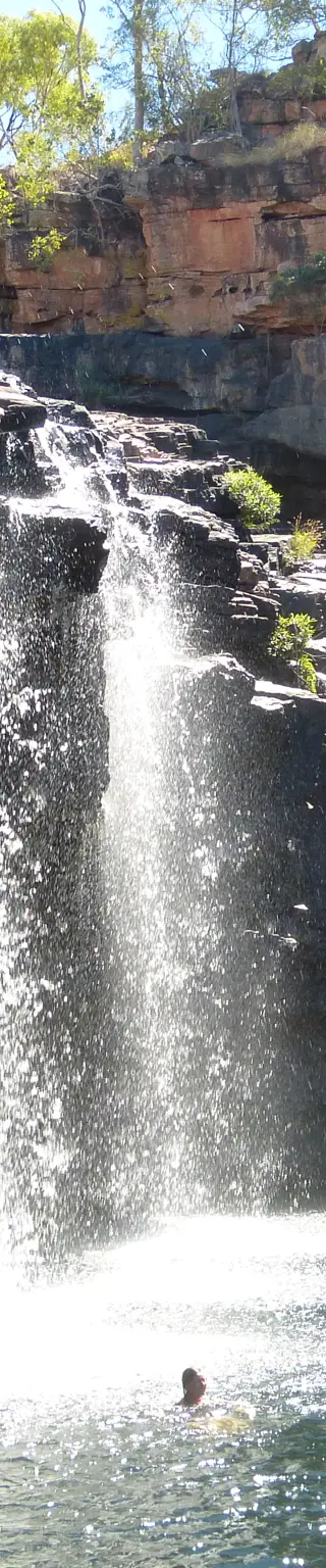 Schwimme unter einem Wasserfall